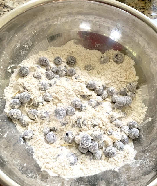 Adding the lemon rind and blueberries into the flour